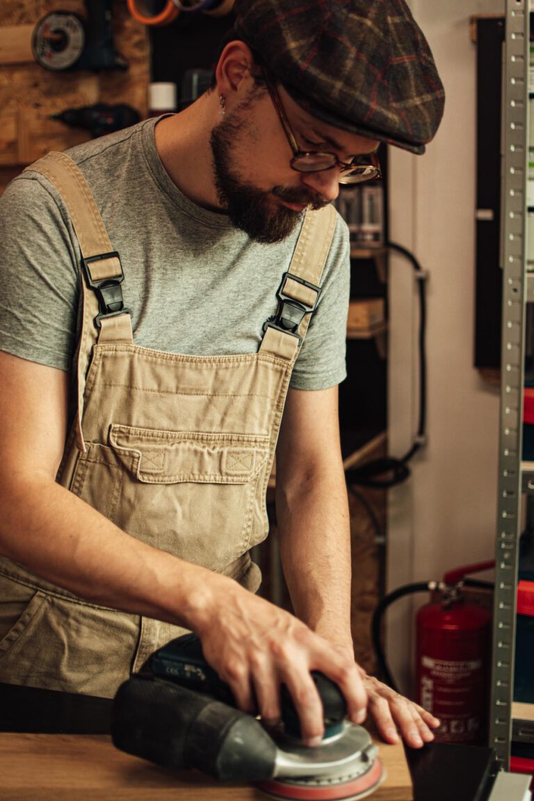 Ambachtelijk meubelmaker Twan is een massief eikenhouten plank voor een maatwerkmeubel aan het schuren in zijn atelier op Strijp-S, Eindhoven.